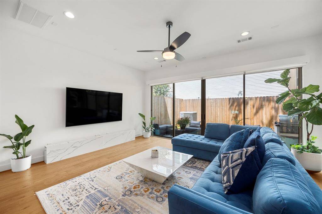 This view highlights the spacious living area with abundant natural light pouring in through the sliding glass doors, offering direct access to the patio and backyard. The clean lines and large windows enhance the room's openness, creating a seamless transition between indoor and outdoor living spaces.