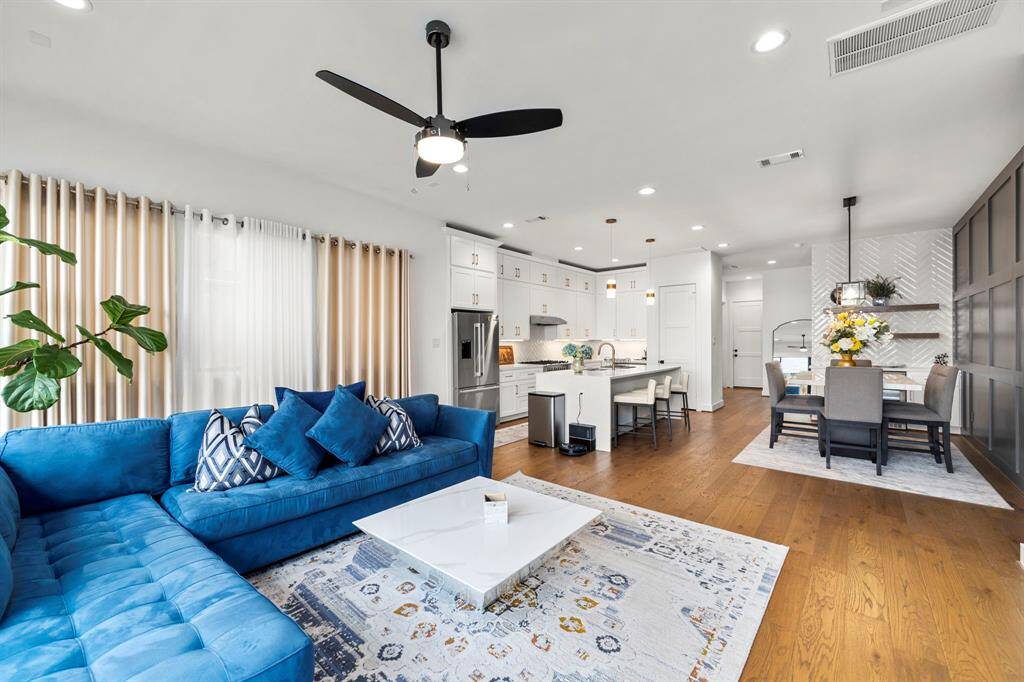 This angle showcases the expansive living room and its seamless connection to the kitchen and dining areas, offering an open-concept layout perfect for modern living. The large windows provide abundant natural light, while the flowing design maximizes space and functionality, making it ideal for both entertaining and day-to-day activities.