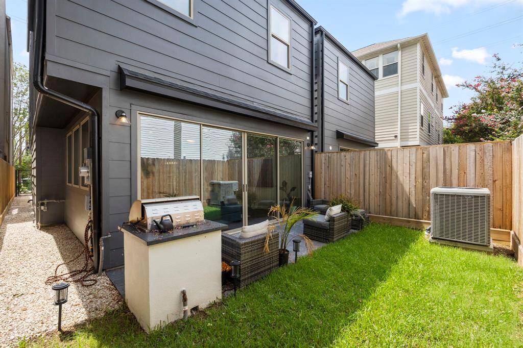 Additional view of the backyard showcases the cozy patio and grill area, seamlessly blending indoor and outdoor living. The pathway to the left offers convenient access from the driveway to the backyard, providing easy flow throughout the property. A well-maintained grassy area adds to the outdoor charm, offering space for relaxation or entertainment.