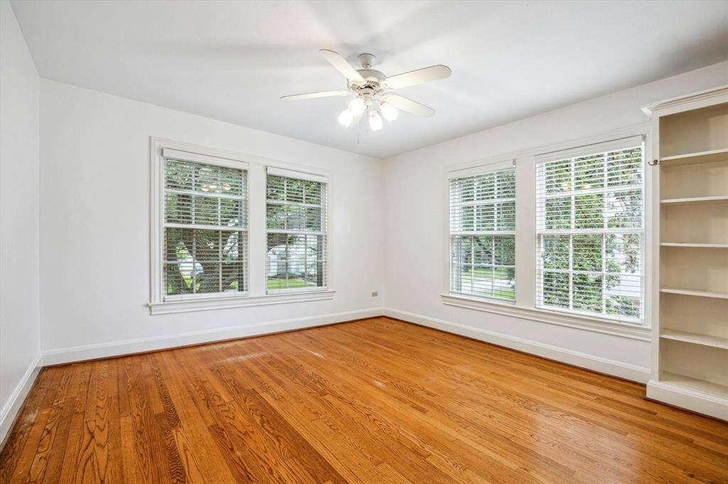 One of the three secondary bedrooms. Note the bookshelves, many windows & pretty wood floors.
