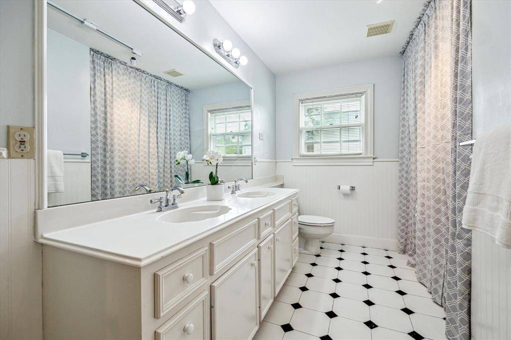 Large hall bath with double sinks and tub/shower.