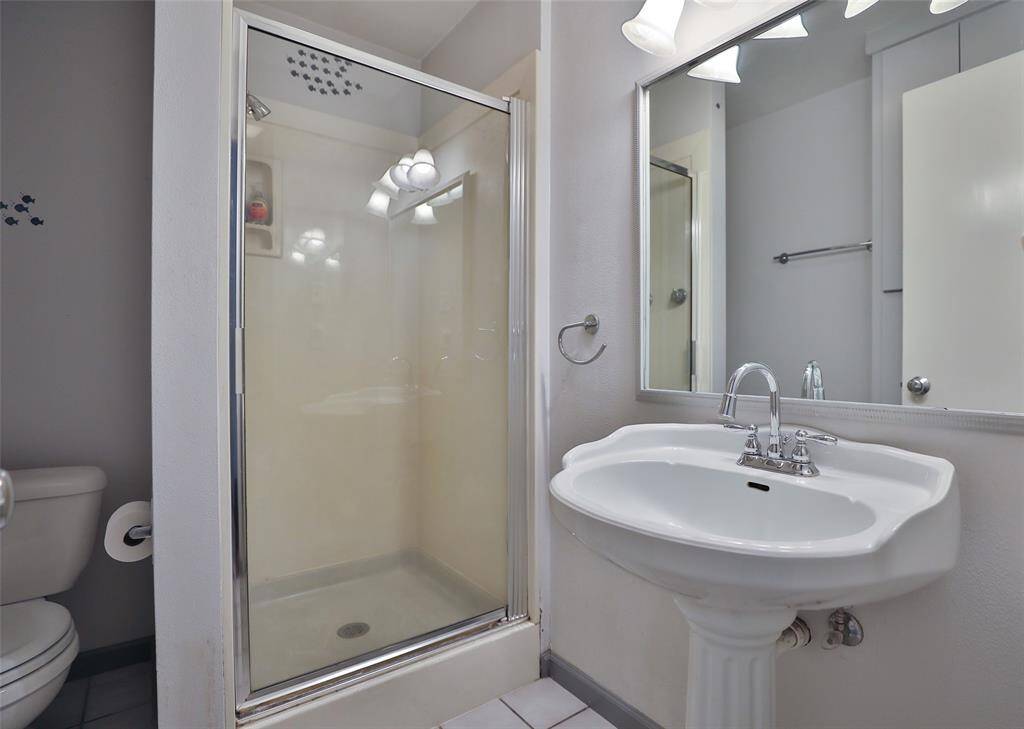 Primary bath with standing shower and pedistal sink.