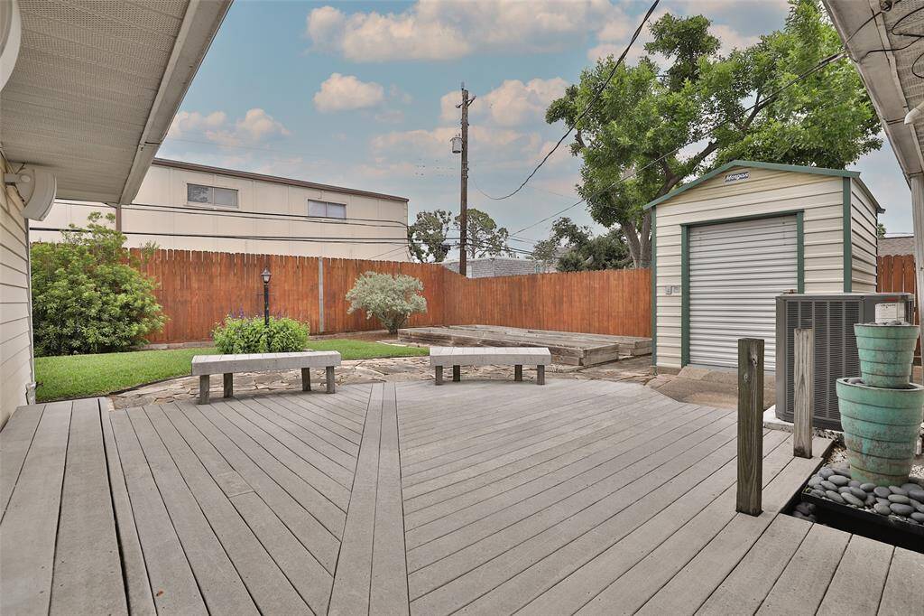 Backyard with oversized decking and storage building.