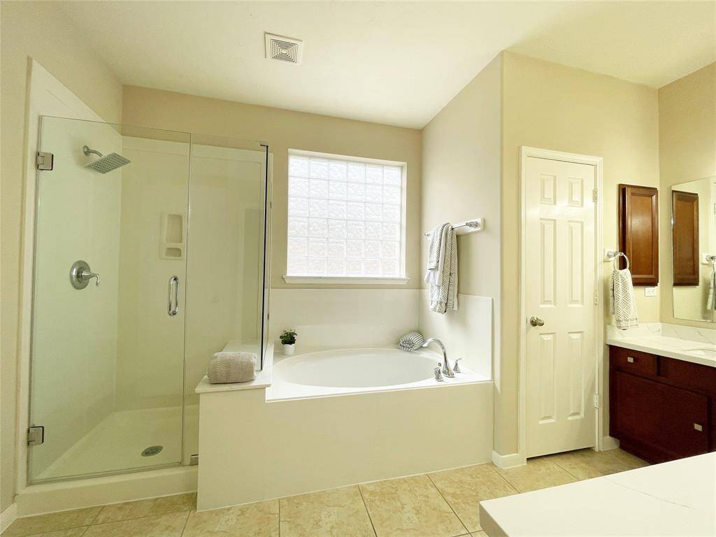 View of the frameless shower door in the primary bathroom.