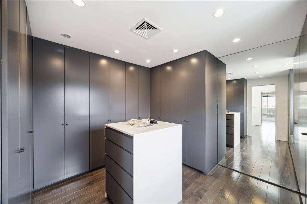 Primary closet with generous amounts of hanging and drawer storage.