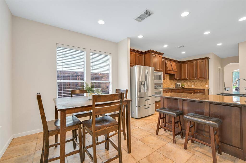 Step into a bright and inviting breakfast room with large windows that fill the space with natural light—perfect for casual meals and morning coffee. The breakfast room blends seamlessly into the kitchen and family room.