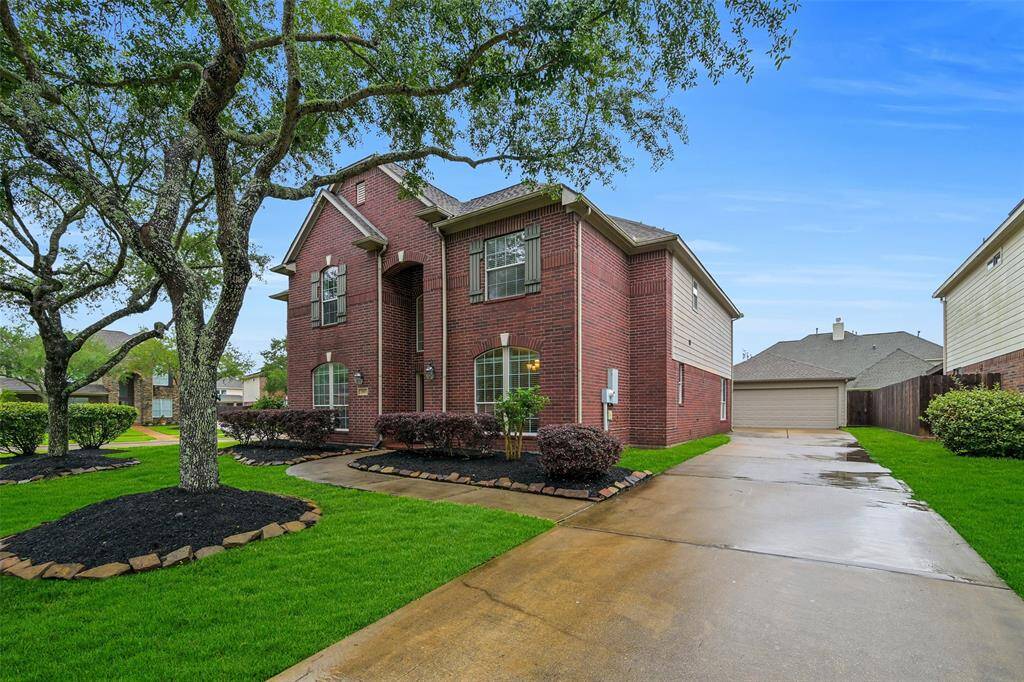 The extended driveway leads to a detached 2-car garage, offering plenty of off-street parking and added privacy. Freshly mulched landscaping and mature trees maintained by an in ground sprinkler system frame this classic red brick elevation for standout curb appeal.