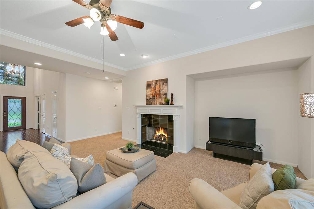 Continue straight ahead into the spacious family room with a cozy gas fireplace with a granite tile surround and a milled wood mantle, recessed lighting, crown molding, and an entertainment niche—open sightlines to the entry enhance the airy feel.