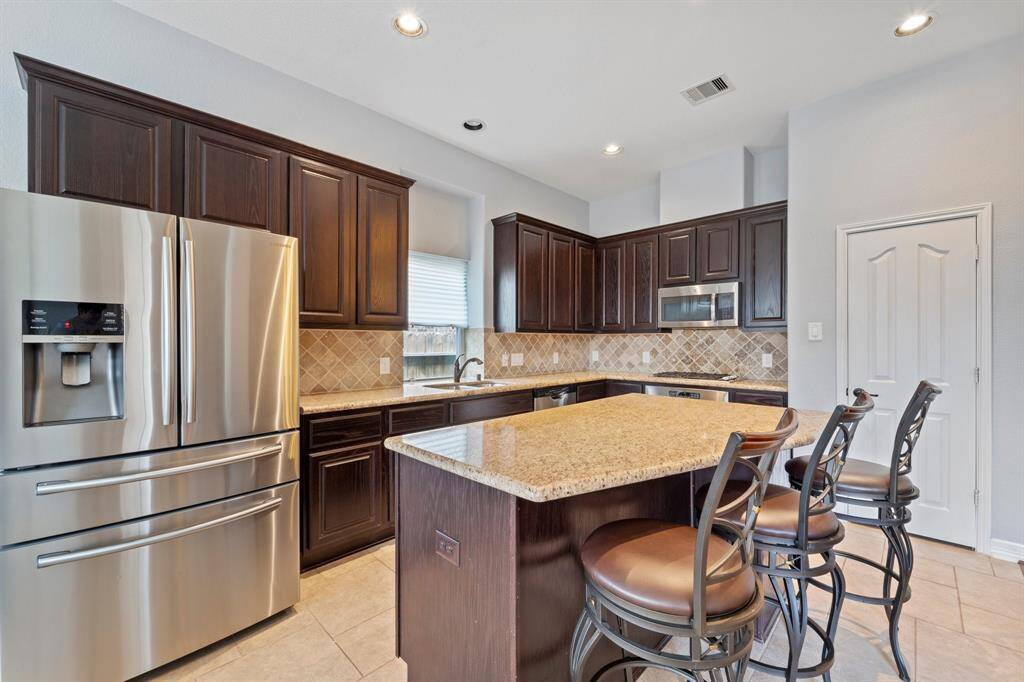 Host your next dinner party with confidence! This masterfully-equipped kitchen features a kitchen island, an abundance of cabinetry, TONS of counter space, granite countertops, recessed lighting and under cabinet lighting, and stainless-steel appliances.
