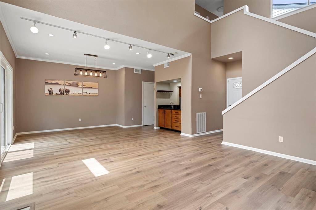 Dining - A perfect space for entertaining with wet bar that opens into the kitchen. Half bath is behind door in center of photo. Entry to the home is on the right. Bedrooms are located upstairs.