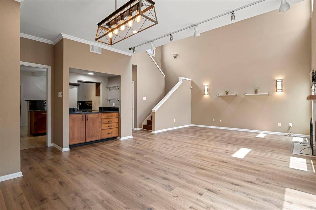 Living - Photographer is standing in the dining area looking toward the bar with kitchen and breakfast area in the background. Living is to the right.