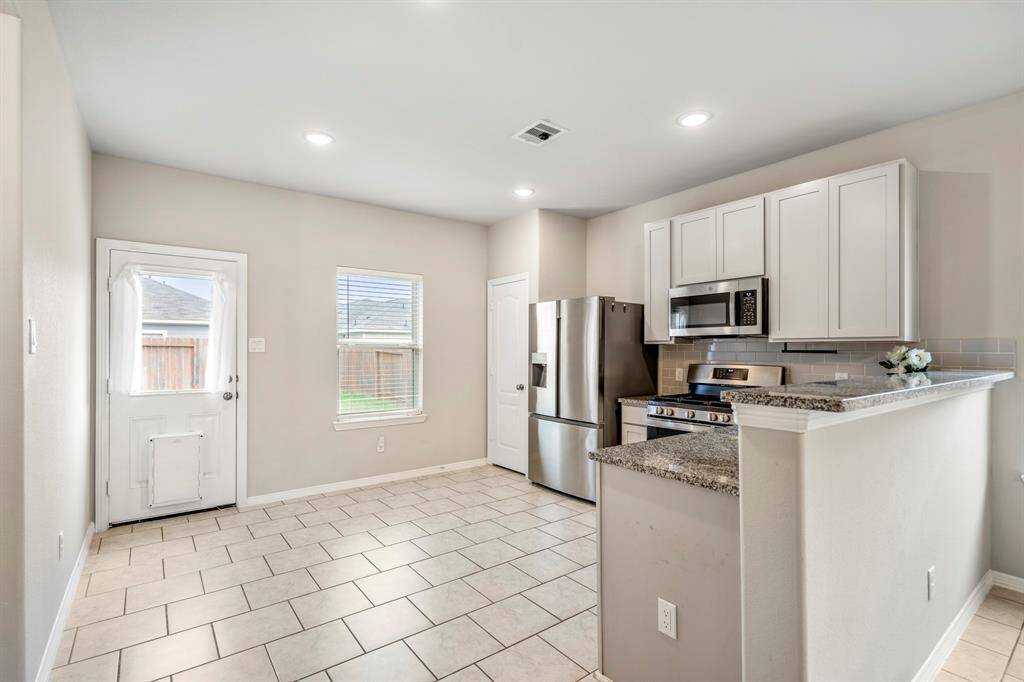 The eye catching kitchen features granite countertops, a Pantry and a door leading to the back Patio