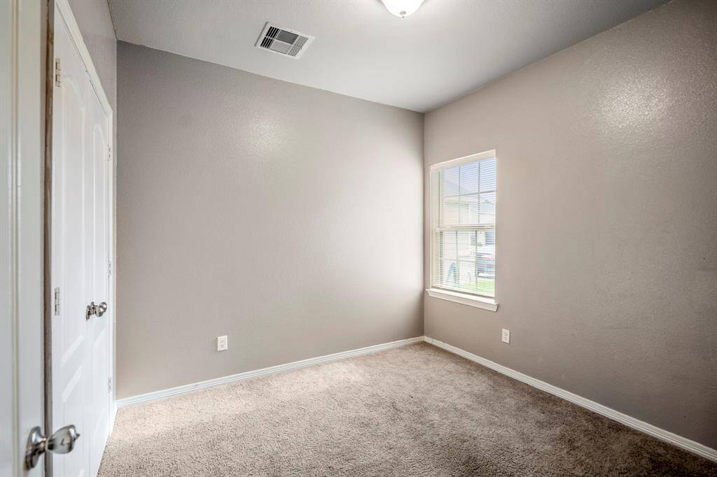 Secondary Bedroom features new paint and a window that overlooks the front of the home.