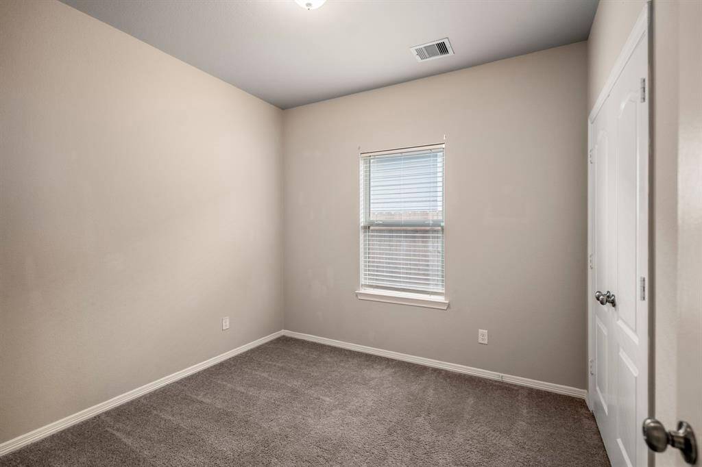Another secondary Bedroom with neutral walls, large closet, and window.