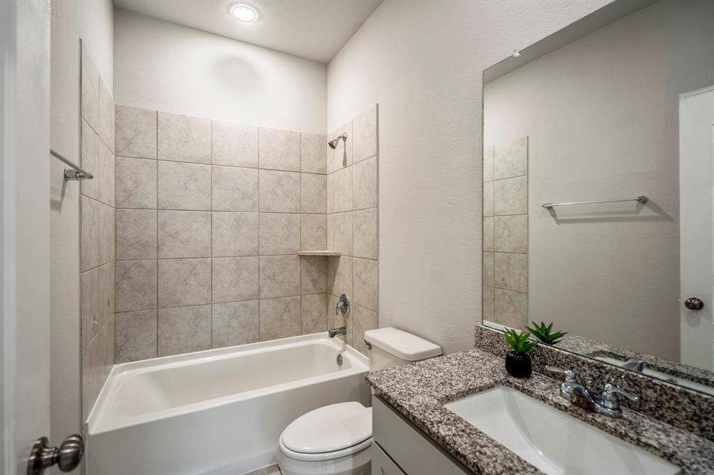 Secondary Bath with a tub/shower combination featuring granite countertops