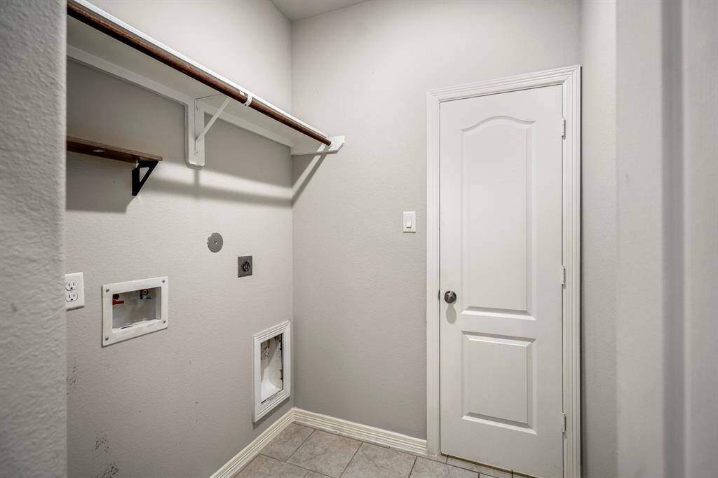 In-house Laundry Room with a drying rack.  The door leads to another storage room with shelving for all your Costco supplies!