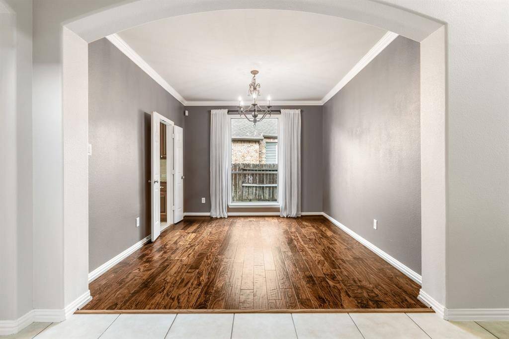 Dining room with engineered wood floors and doors leading to the kitchen.