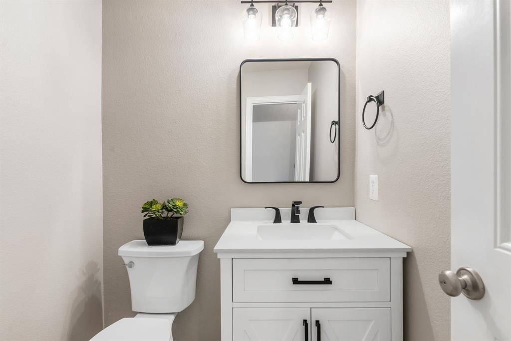 Half bath downstairs with updated vanity, mirror and lighting.