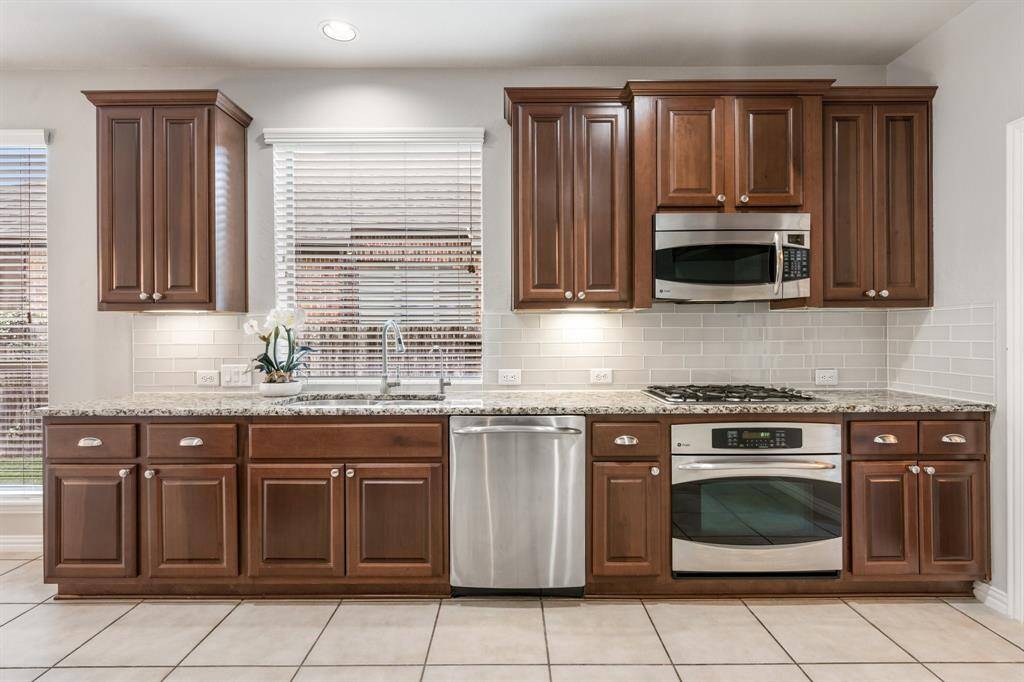Kitchen with stainless steel appliances, udated subway tile backsplash and gas range.