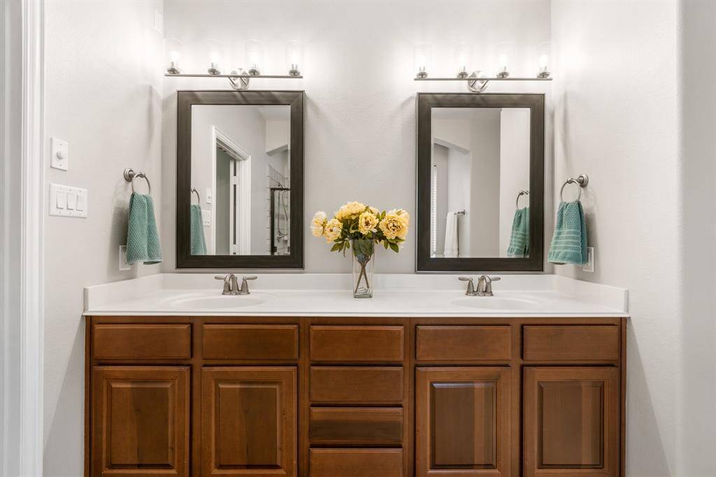 Primary bathroom with updated lighting and mirrors.