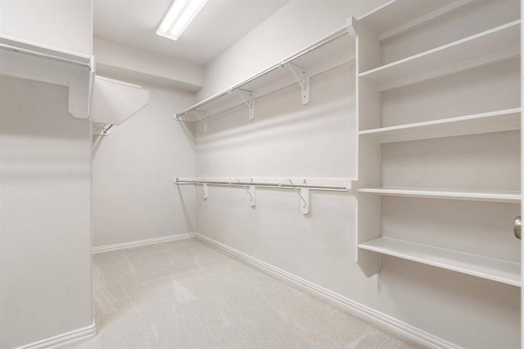 Huge pirmary closet with shelves and a linen closet.