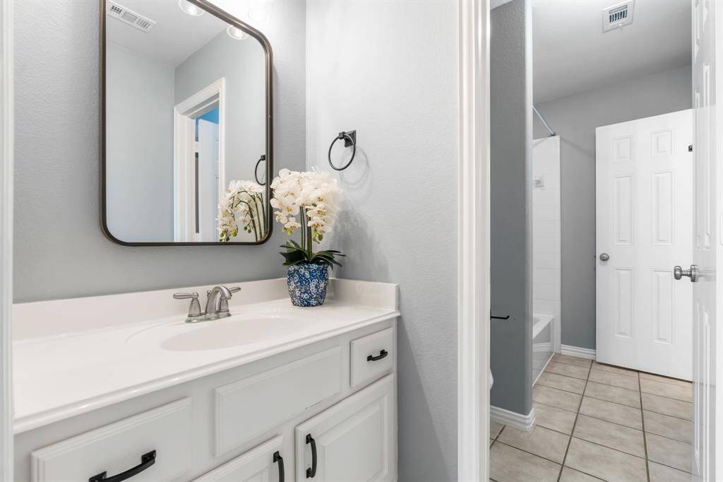 ack and Jill bathroom with updated lighting and mirror.