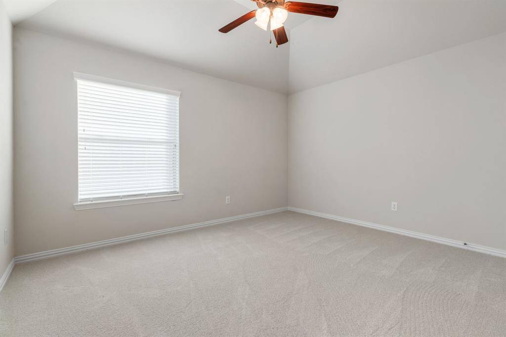 Secondary bedroom upstairs with ceiling fan and walk in closet.