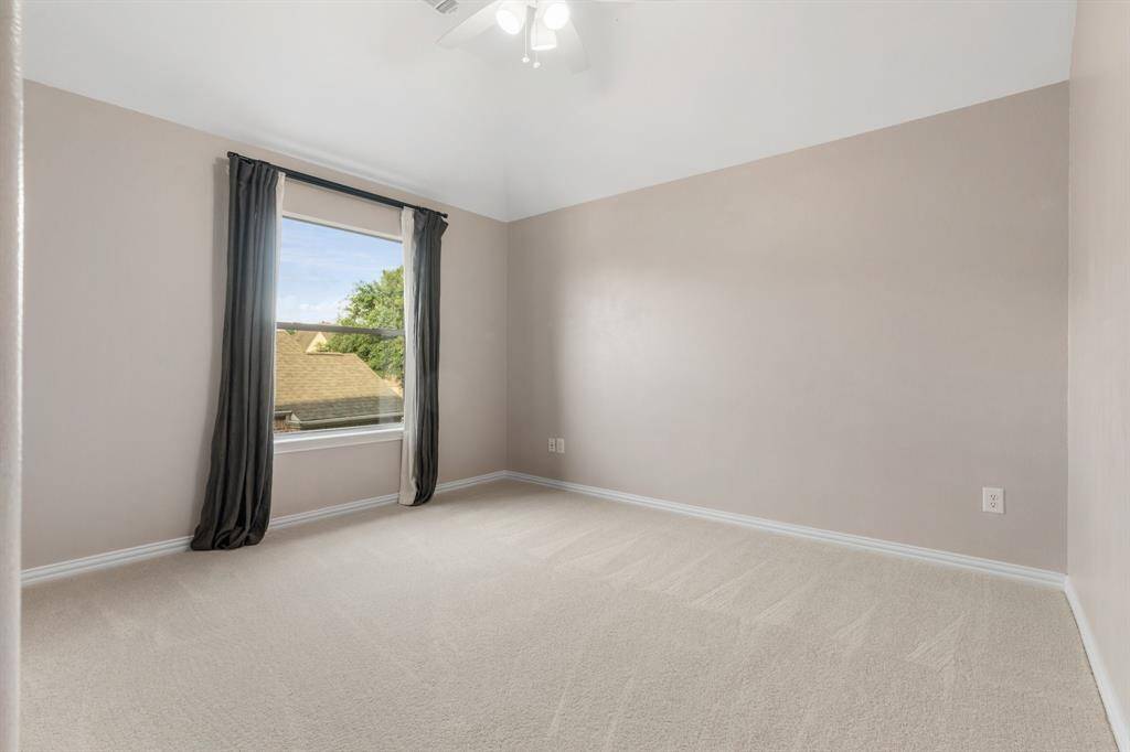 Secondary bedroom upstairs with walk in closet, window treatment, ceiling fan and it's own en suite bathroom and linen closet.
