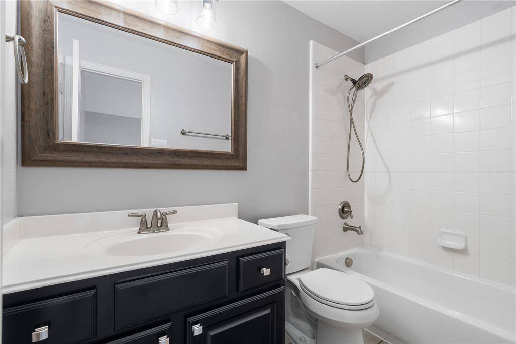 En suite bathroom in upstairs secondary bedroom.  Updated lighting, mirror and painted vanity.