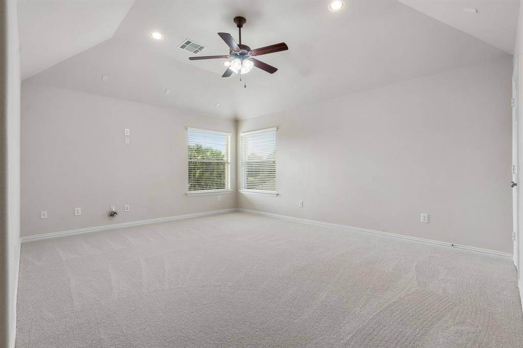 Upstairs game room with ceiling fan and storage closet with shelving.