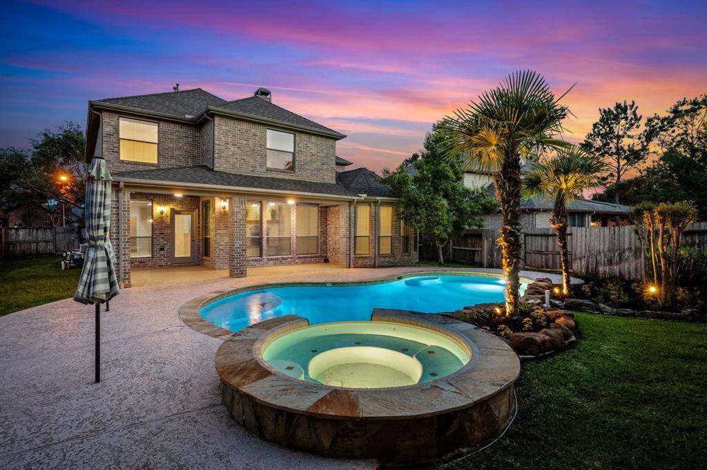 Backyard oasis showing the pool with hot tub and nice size covered patio with plenty of room for table, chairs and a separate sitting area.
