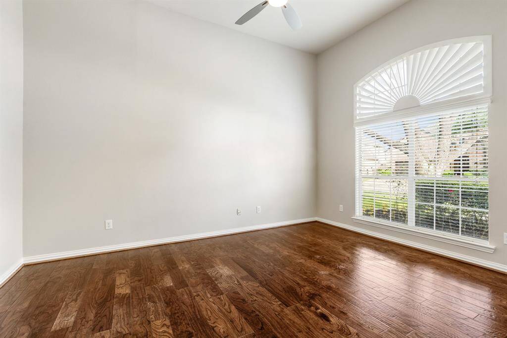 Spacious office has engineered wood floors, ceiling fan and a few of the front lawn.