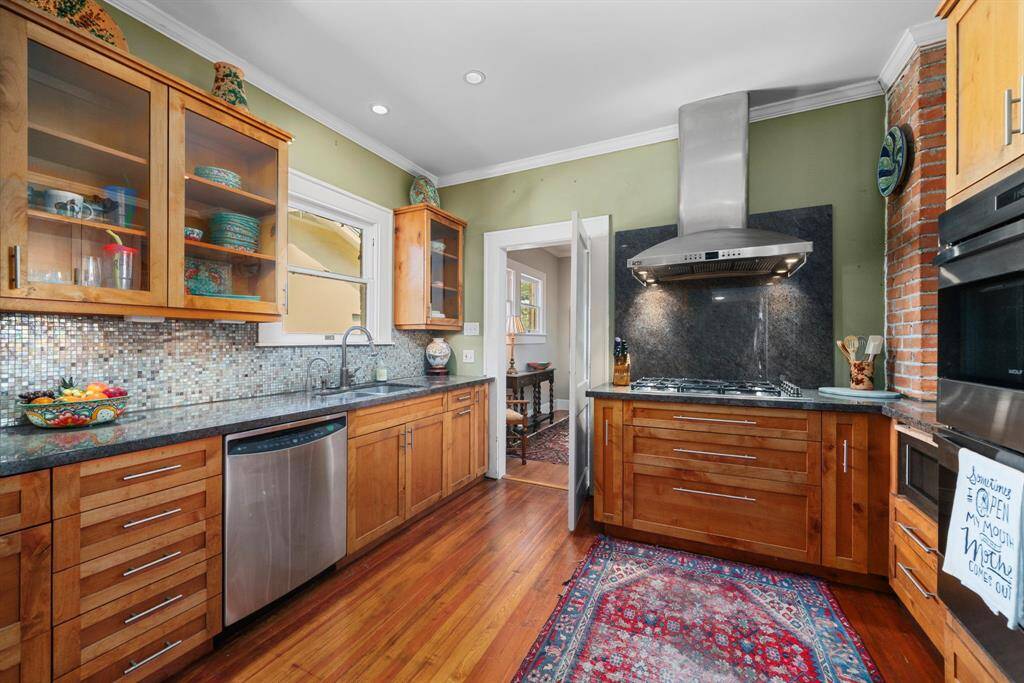The updated kitchen truly maximizes both storage and functionality. All wood cabinetry, Wolf appliances, granite countertops, tile backsplash are just a few of the thoughtful elements in this space.