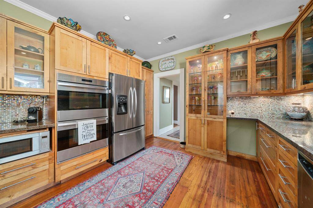 The combination of both glass front and solid cabinet fronts allow you space to display your collectibles, and hide the everyday use items for a clean feel. This doorway ahead leads to laundry and storage, as well as the rear flex space.