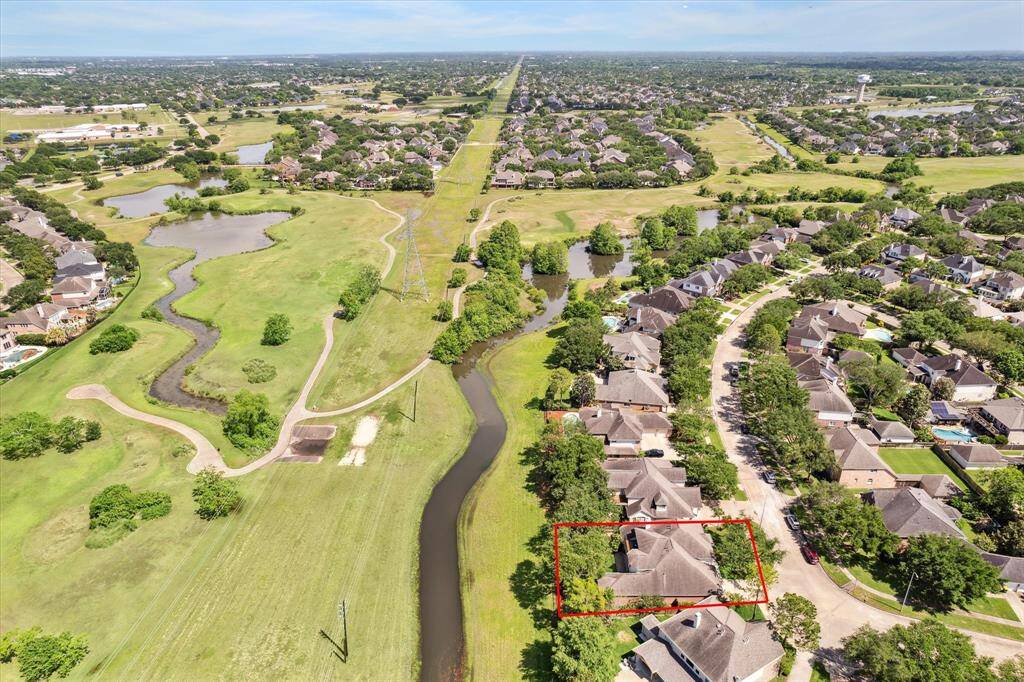 Your fenced yard backs up to the greenbelt. In the distance you see Southwyck Golf Club.