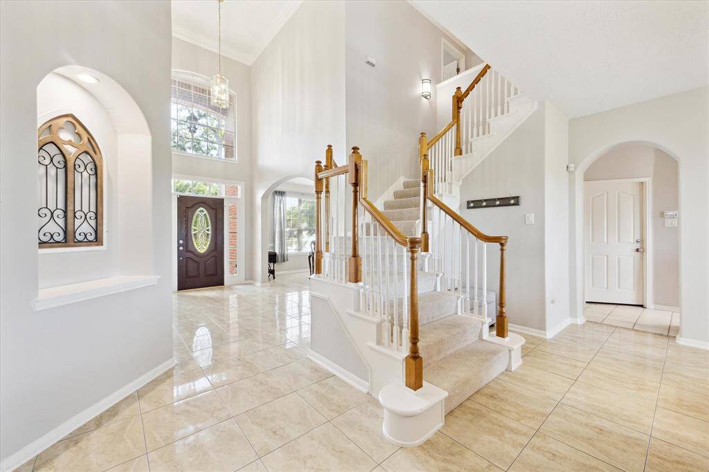 The soaring formal entryway is flanked by a living room (could be an office) and formal dining room.