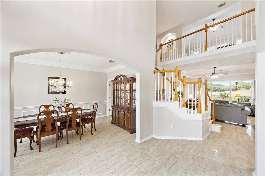 Here you see the formal dining room. Note the lofty openness of the high ceilings and views of the art niches that flank the upstaris game room.