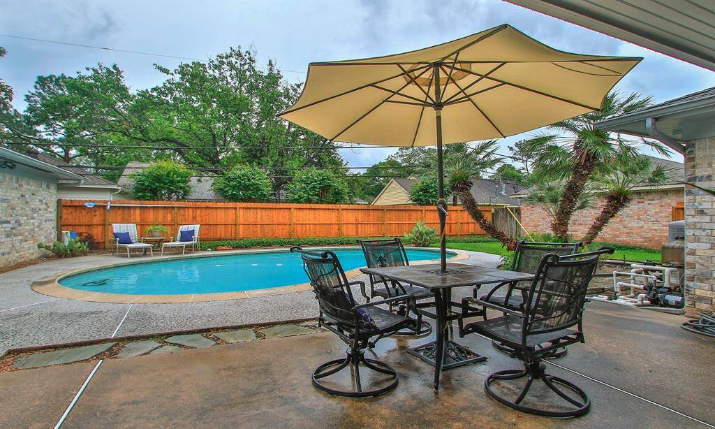 Patio overlooking the pool area. New fence across the backyard
