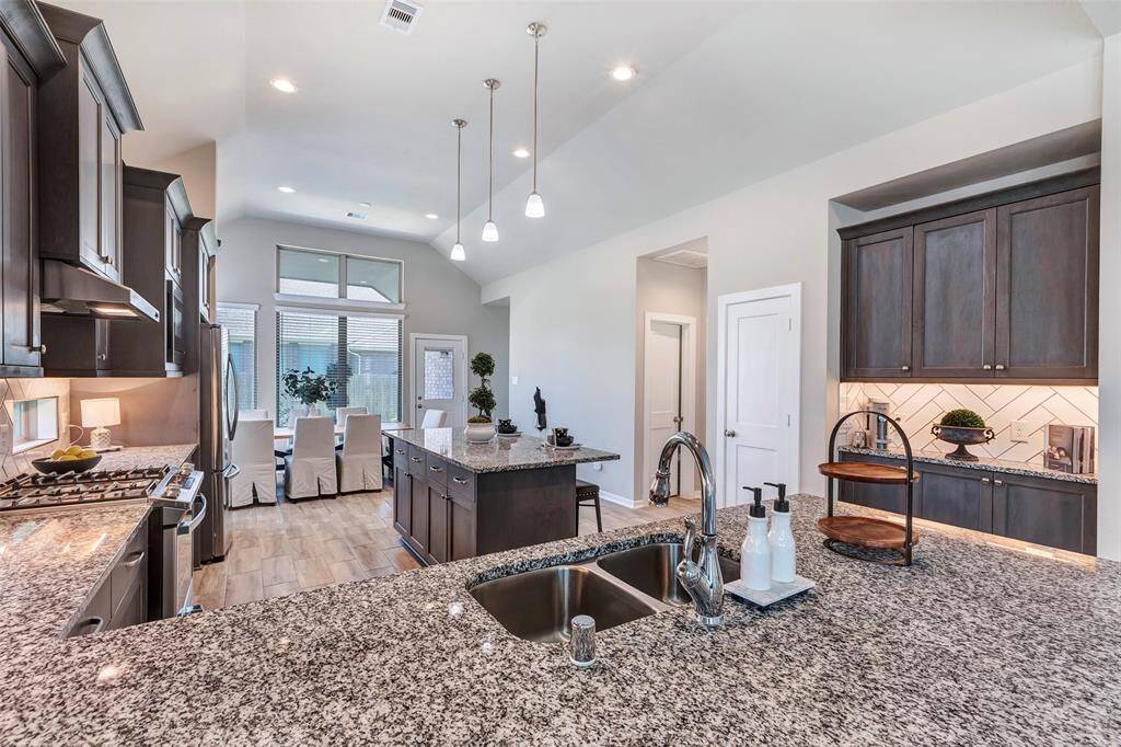 The kitchen features double sinks for added convenience and stylish drop lights above the center island, adding both function and charm to the space.