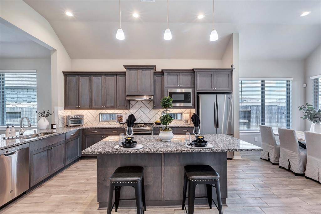 The kitchen island at the center serves as a convenient breakfast bar, offering a casual spot for meals and extra counter space for cooking.