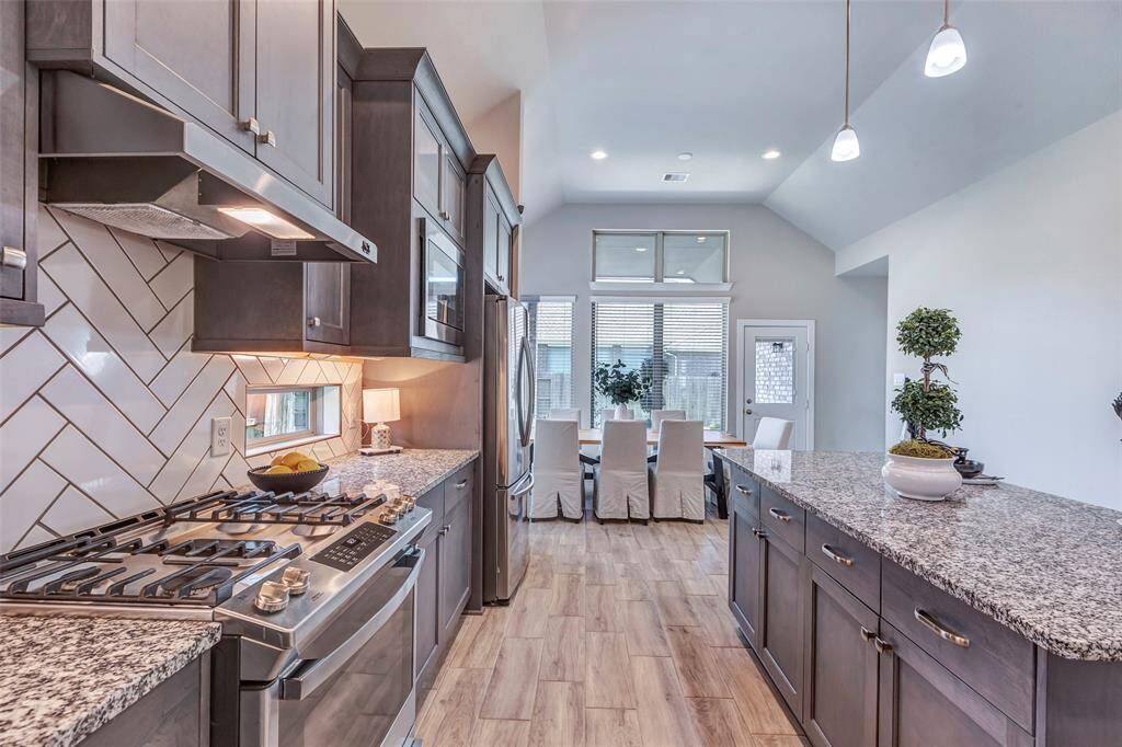 This view from the kitchen captures the inviting dining area, with an open door beyond that leads to the primary bedroom, offering easy access and a seamless flow between spaces.