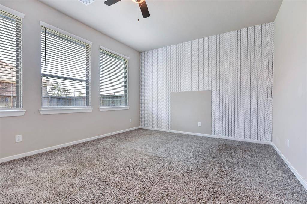 Welcome to the primary bedroom, featuring plush carpeted floors and large windows that fill the space with natural light, creating a warm and inviting atmosphere.