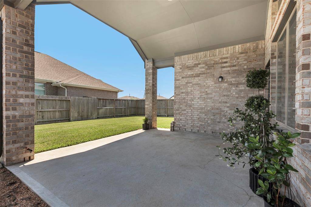 Step through the back door and relax on the covered patio, where you can enjoy the serene view of the backyard in comfort and style.