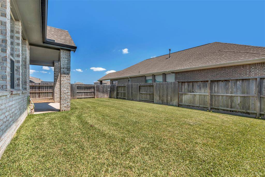 The backyard is beautifully enclosed by a tall wooden fence, offering both privacy and a peaceful, secluded outdoor space.