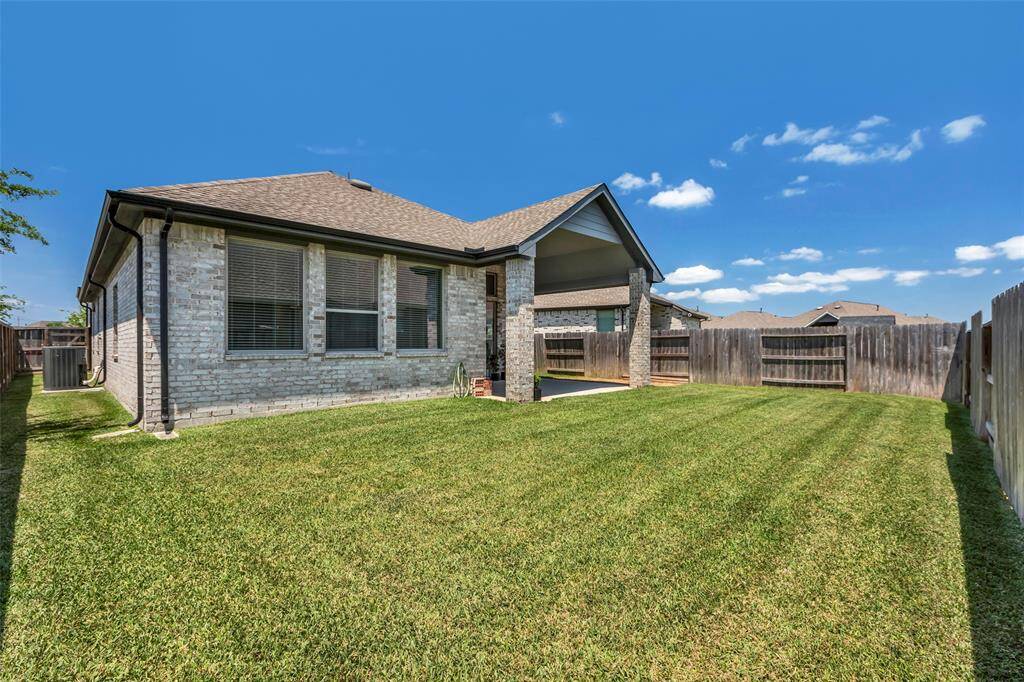 The backyard features lush, green grass, creating a vibrant and inviting outdoor space for relaxation or play.