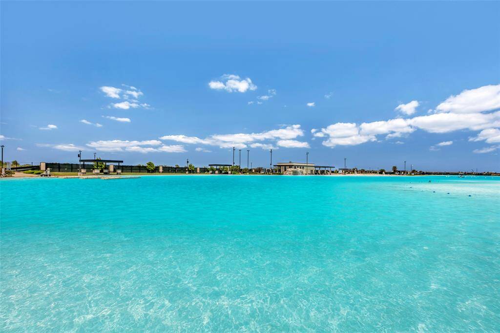 A stunning view of the expansive swimming pool, its waters beautifully reflecting the azure color of the sky.