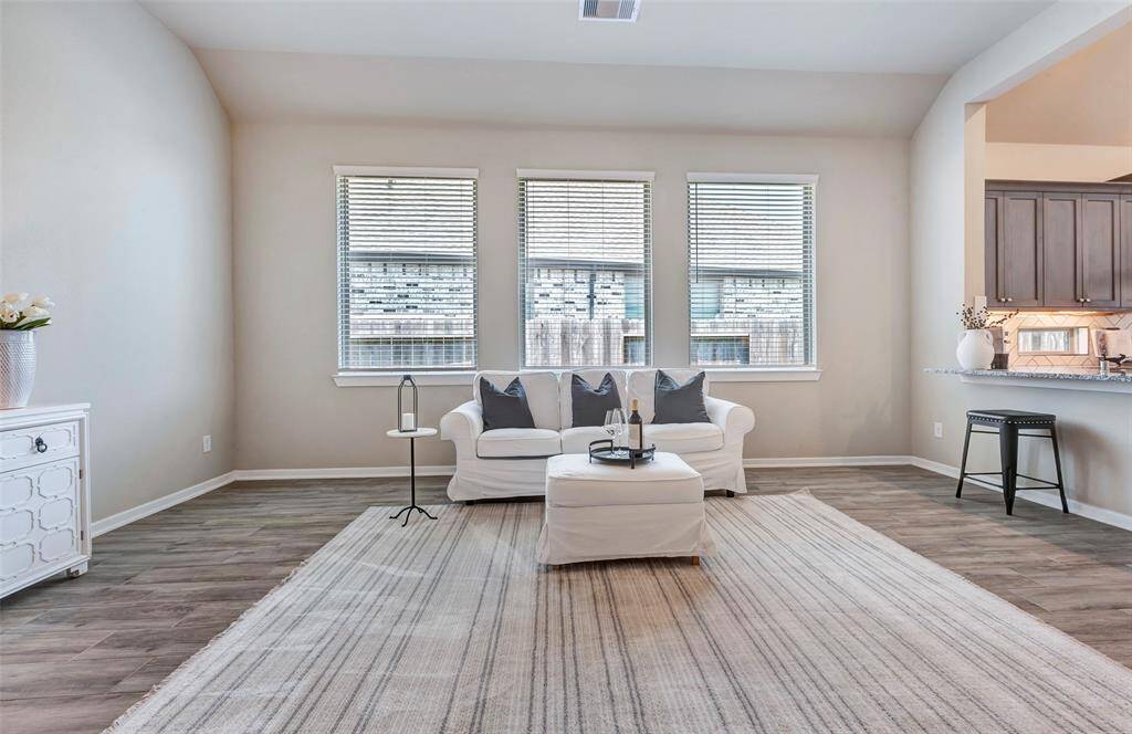 This full view of the living room showcases its bright, open feel with large windows offering a beautiful look out to the wraparound backyard.