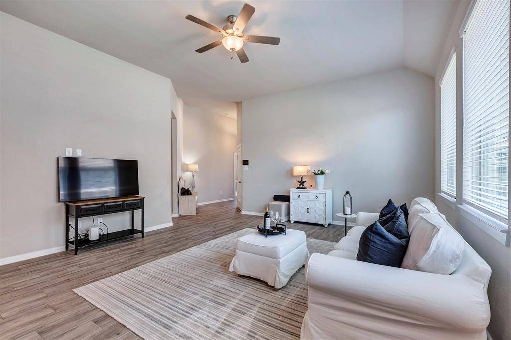 Another view of the living room reveals the welcoming foyer and that open door that leads to a hallway connecting to additional rooms throughout the home.