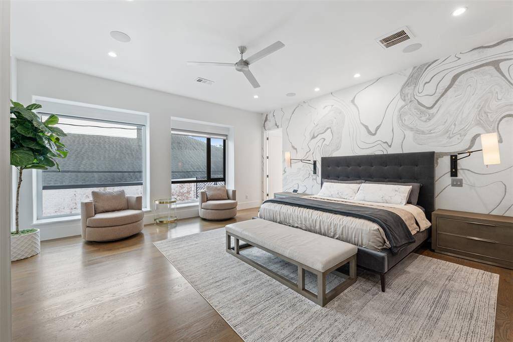 The beautiful spacious primary suite is loated on the second floor and features a contemporary accent wall and the clean lines keeps the room fresh