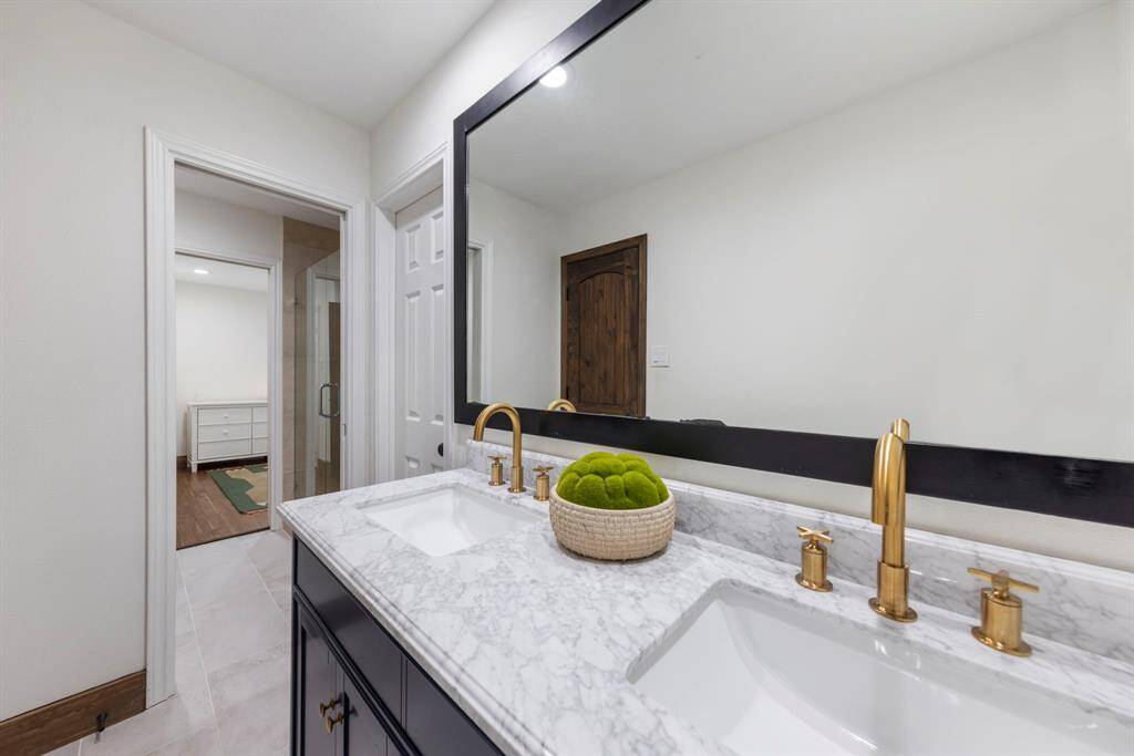 Jack and Jill secondary bathroom includes dual sinks and a walk-in shower.